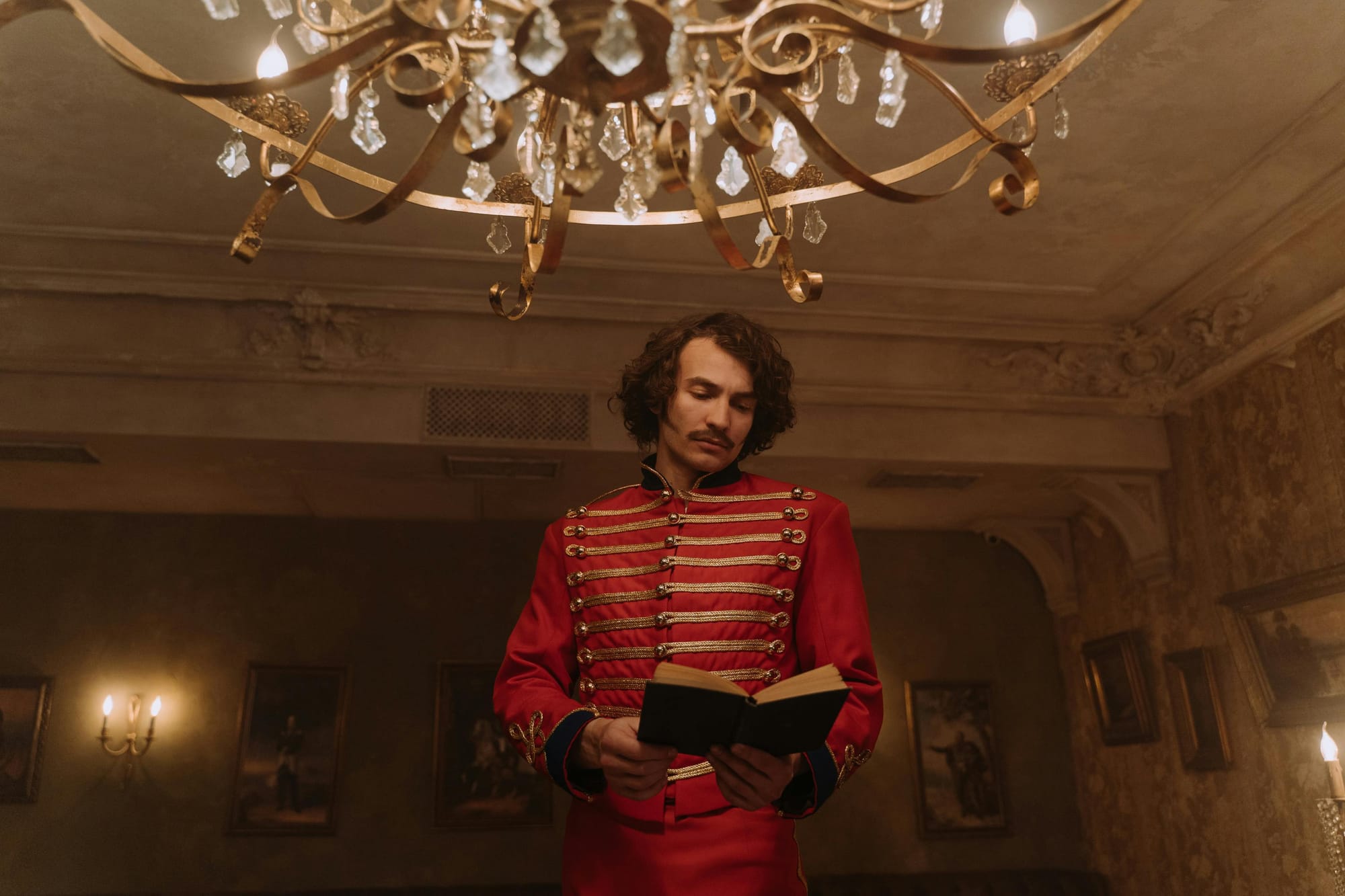 a man in a historical uniform standing and reading a book