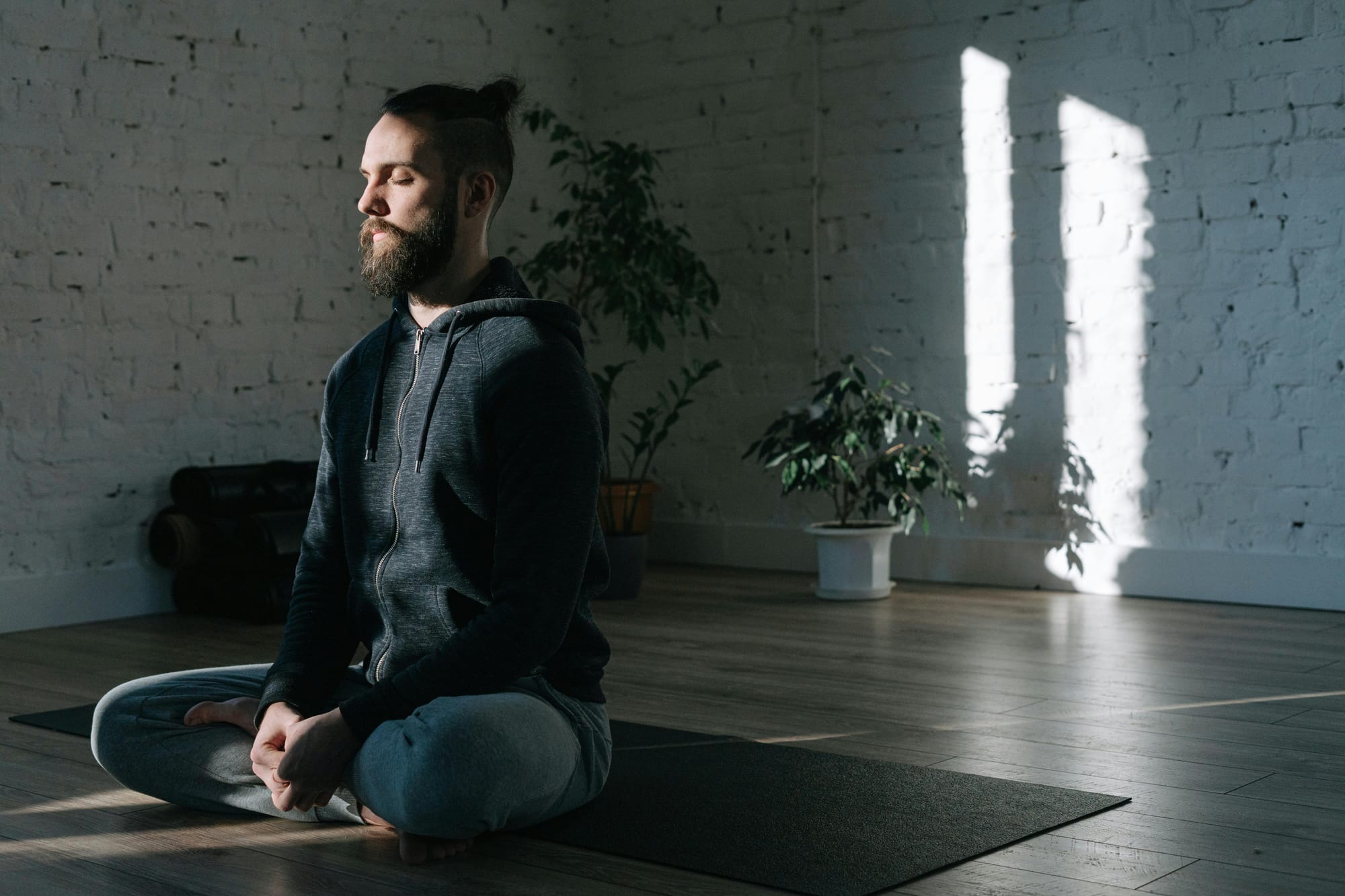 calm and concentrated man sitting in meditation on a mat