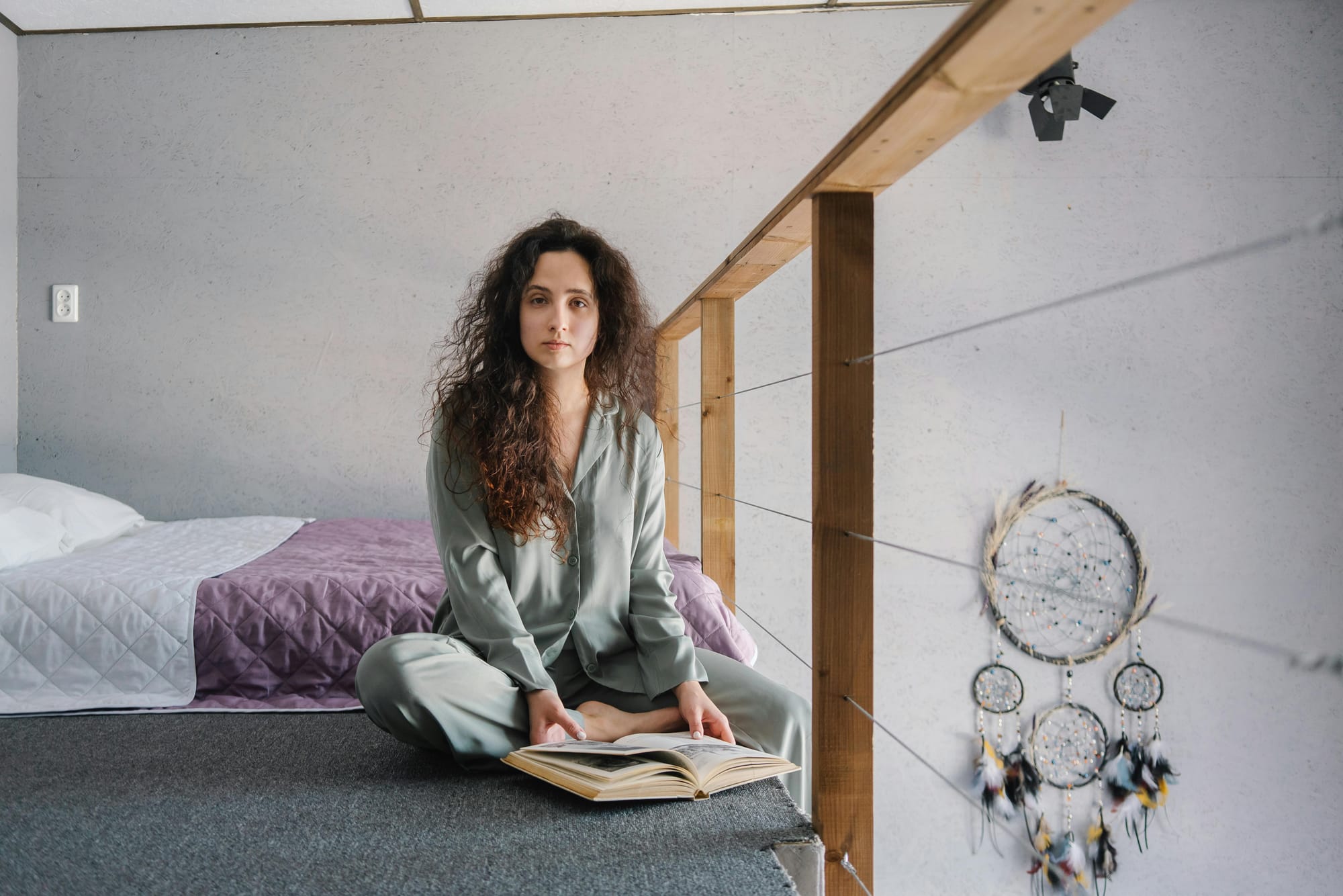 woman sitting cross-legged with a book in bed