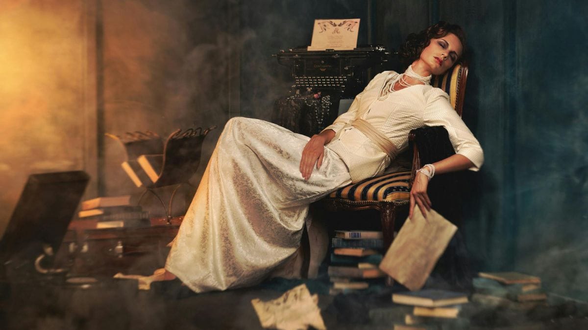 woman lying on a chair surrounded by books
